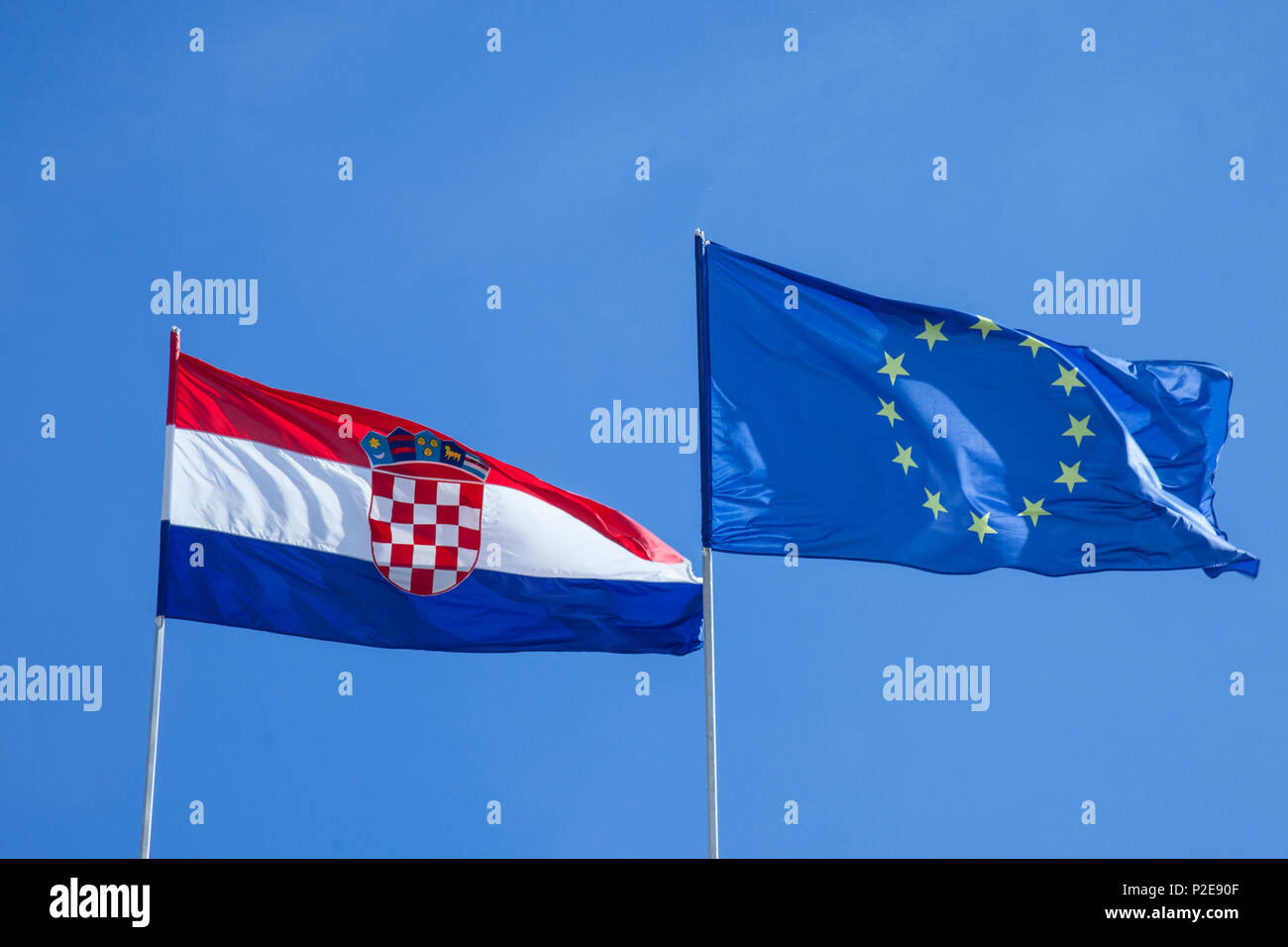 Il croato e bandiere europee rinuncia in aria con un cielo blu sullo sfondo. La Croazia è il paese più giovane che hanno aderito all'Unione europea nel 2013 Pic Foto Stock