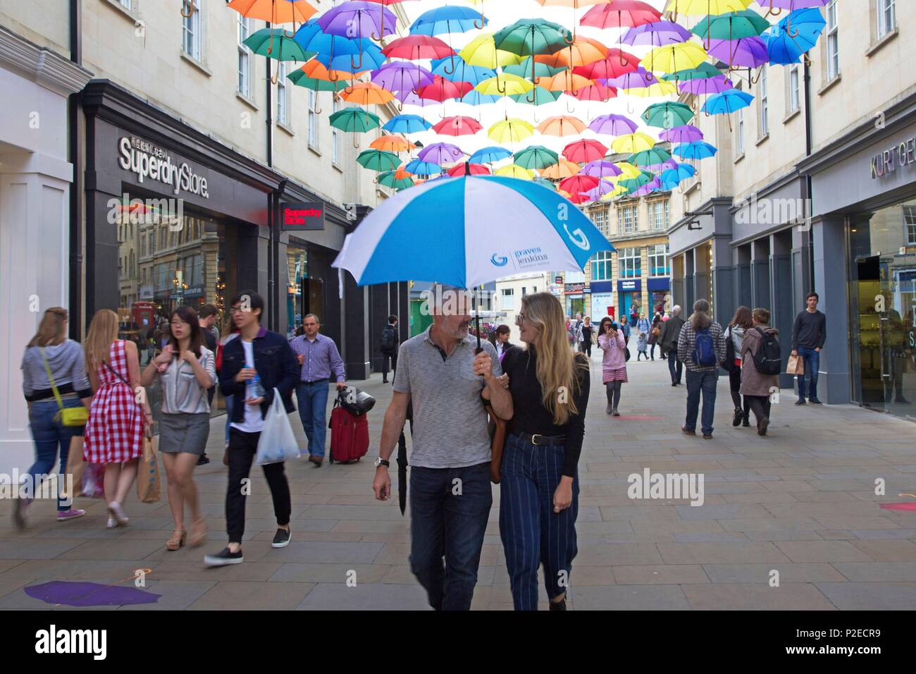 Regno Unito, Somerset county, bagno, giovane sotto il suo ombrello nel centro commerciale e pedonale South Gate street Foto Stock