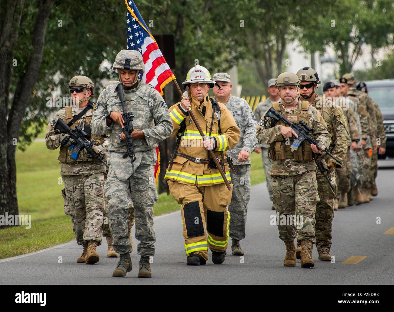 Master Chief Sgt. Pete Webb, 919th Special Operations Wing, porta una bandiera giù per la strada verso il sito di dell'unità 9/11 Cerimonia Commemorativa sett. 11 al duca Campo, Fla. il capo è stato scortato da ala delle forze di sicurezza di membri. La bandiera ha effettuato è stato usato durante la 24 Ore di Memorial salire scale evento che ha iniziato il giorno prima. La salita di scale caso culminata nella consegna della bandiera alla cerimonia di commemorazione. (U.S. Air Force foto/Tech. Sgt. Sam re) Foto Stock