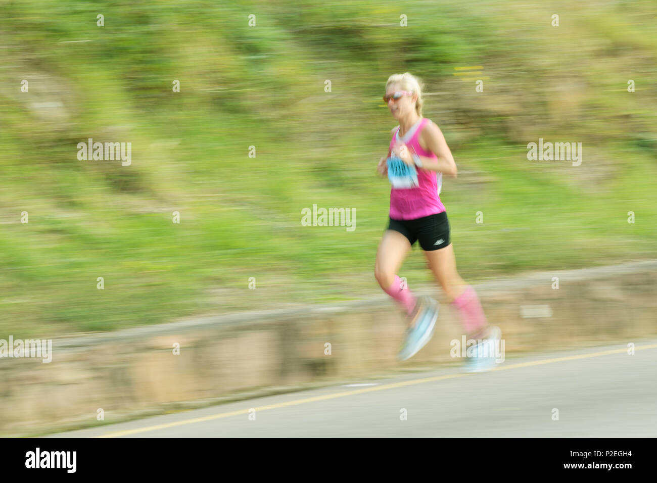Durban, KwaZulu-Natal, Sud Africa, bionda donna adulta in esecuzione concorrente fortemente, Bothas Hill, 2018 compagni marathon, runner, le persone, le sfocature Foto Stock