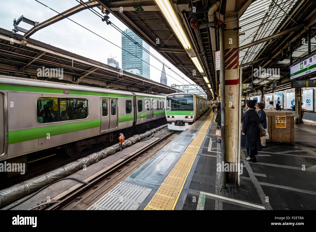 I passeggeri in attesa del treno della linea Yamanote sulla pista di Stazione di Shinjuku, Shinjuku, Tokyo, Giappone Foto Stock