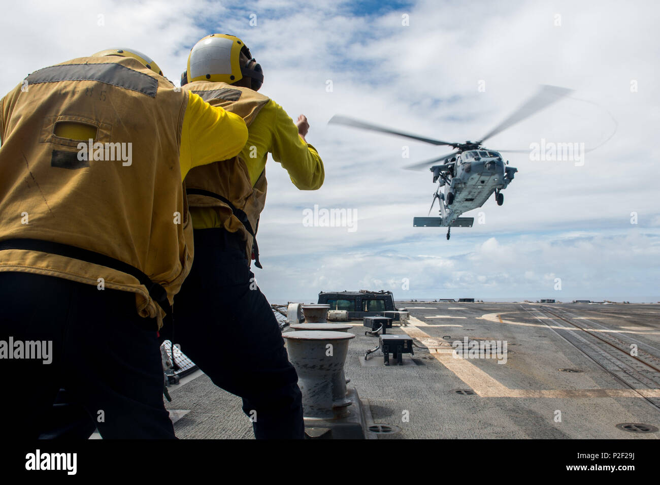 160907-N-NT265-008 Mare delle Filippine (sett. 7, 2016) Electronics tecnico di terza classe Robert McGuire, assegnato all'distribuita Arleigh Burke-class guidato-missile destroyer USS McCampbell (DDG 85), dirige un MH-60S Sea Hawk elicottero, assegnato al "falchi d'Oro" di elicottero di mare squadrone di combattimento (HSC) 12, durante il suo avvicinamento al ponte di volo. McCampbell è di pattuglia con un Carrier Strike gruppo cinque (CSG 5) nel Mare delle Filippine il supporto di sicurezza e stabilità nella Indo-Asia-regione del Pacifico. (U.S. Foto di Marina di Massa Specialista comunicazione di seconda classe Senyk cristiana/rilasciato) Foto Stock