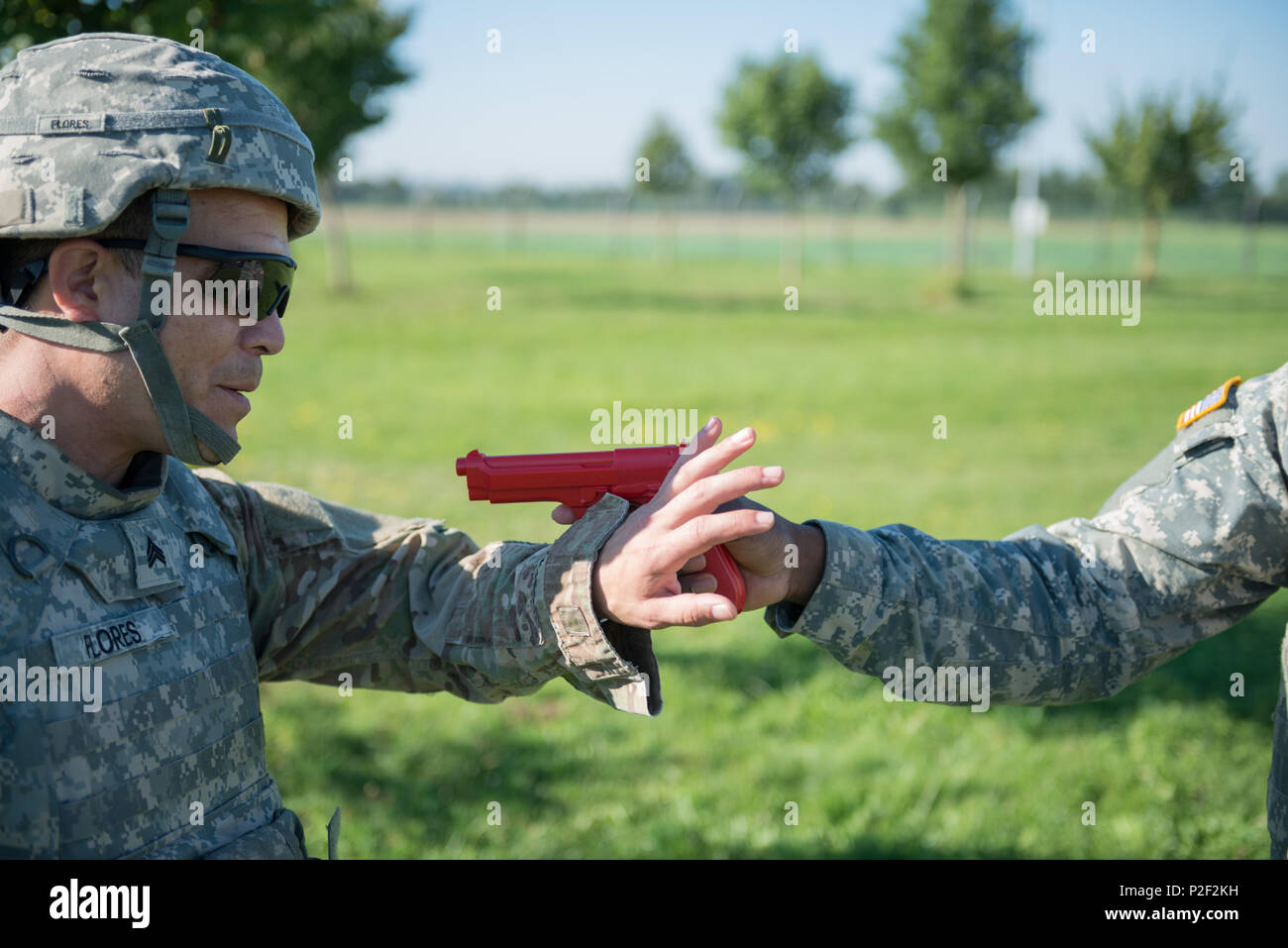 Stati Uniti Army Sgt. Carlos Flores, con 128Signal Company, mostra come deflettere lontano una simulazione di M9 pistola, per allontanarlo dal suo avversario, come insegna reagiscono all'uomo a contatto con i soldati assegnati alla sua unità, sul Wingene Air Base, Sett. 08, 2016. (U.S. Esercito foto di Visual Information Specialist Pierre-Etienne Courtejoie) Foto Stock