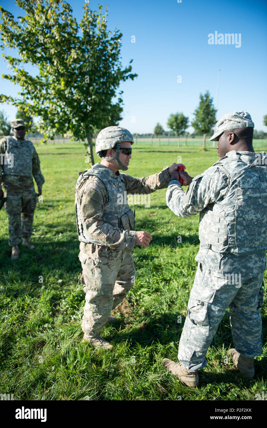 Stati Uniti Army Sgt. Carlos Flores, con 128Signal Company, afferra Spc. Mohamed Toure mock del M9 pistola, per allontanarlo dal suo avversario, come insegna reagiscono all'uomo a contatto con i soldati assegnati alla sua unità, sul Wingene Air Base, Sett. 08, 2016. (U.S. Esercito foto di Visual Information Specialist Pierre-Etienne Courtejoie) Foto Stock