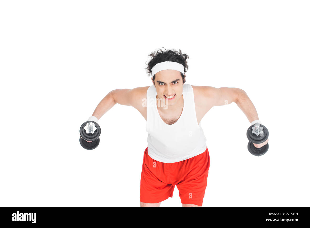 Ritratto di giovane uomo sottile in sportswear esercizio con manubri isolato su bianco Foto Stock