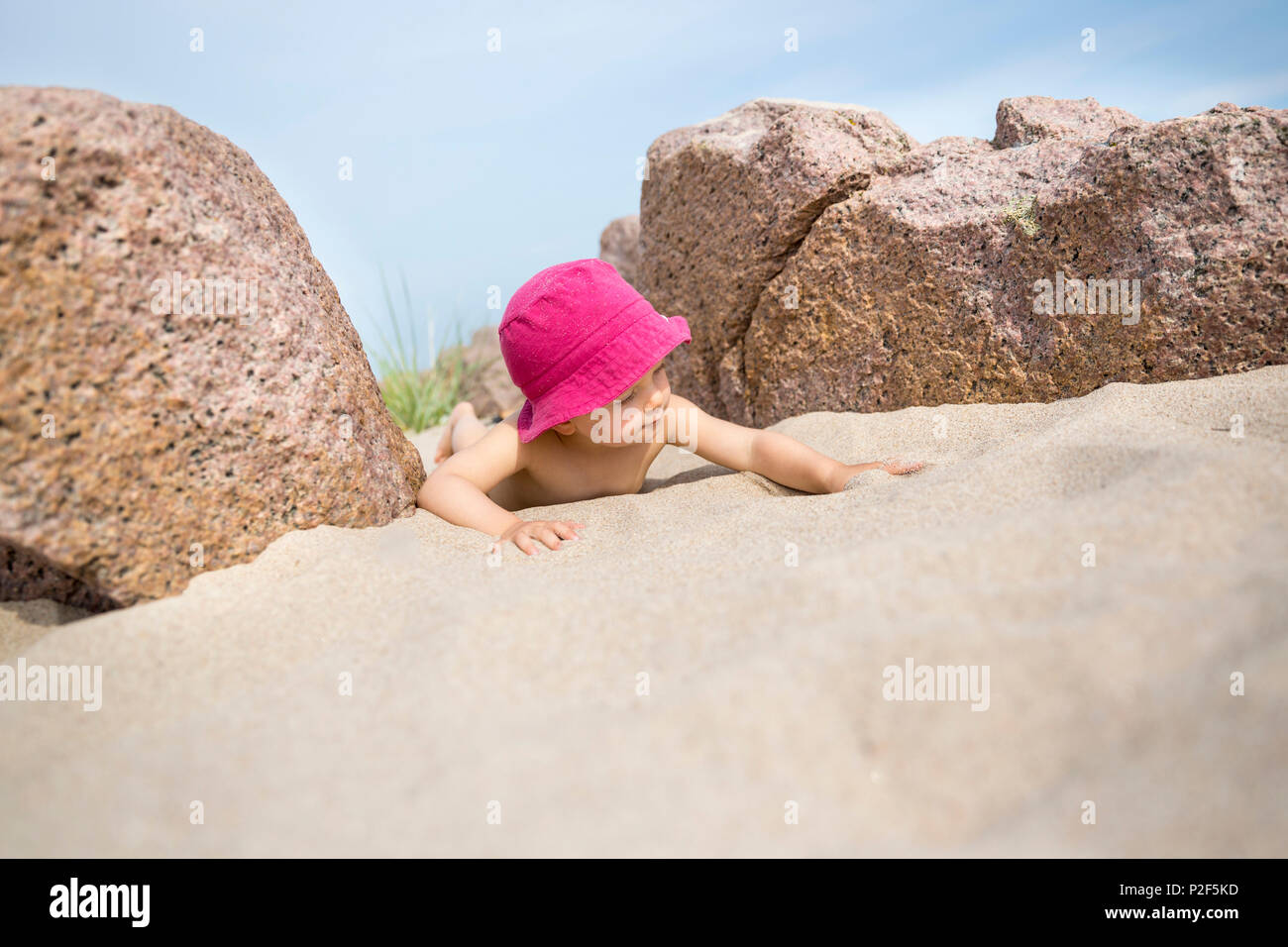 Bambina con cappello per il sole giocando sulla spiaggia, estate, vacanze, famiglia, Mar Baltico, Signor, Bornholm, Sandvig, Danimarca, Europa Foto Stock