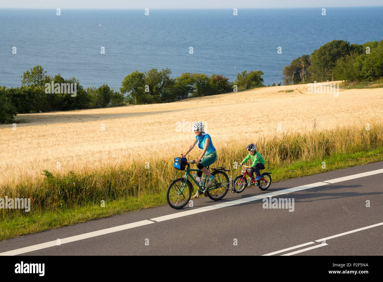 Madre e figlio su y ciclo tour vicino a cornfield, Mar Baltico, Signor, Bornholm, vicino Gudhjem, Danimarca, Europa Foto Stock