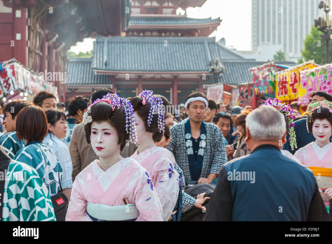 Tre Geisha e uomo in uno yukata con passeggino durante il Sanja Matsuri Asakusa, Tokyo, Giappone Foto Stock