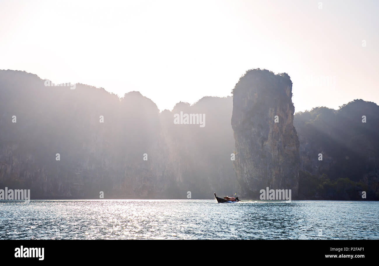 Barca dalla coda lunga in corrispondenza delle isole tropicali a sunrise nel mare delle Andamane, Thailandia Foto Stock