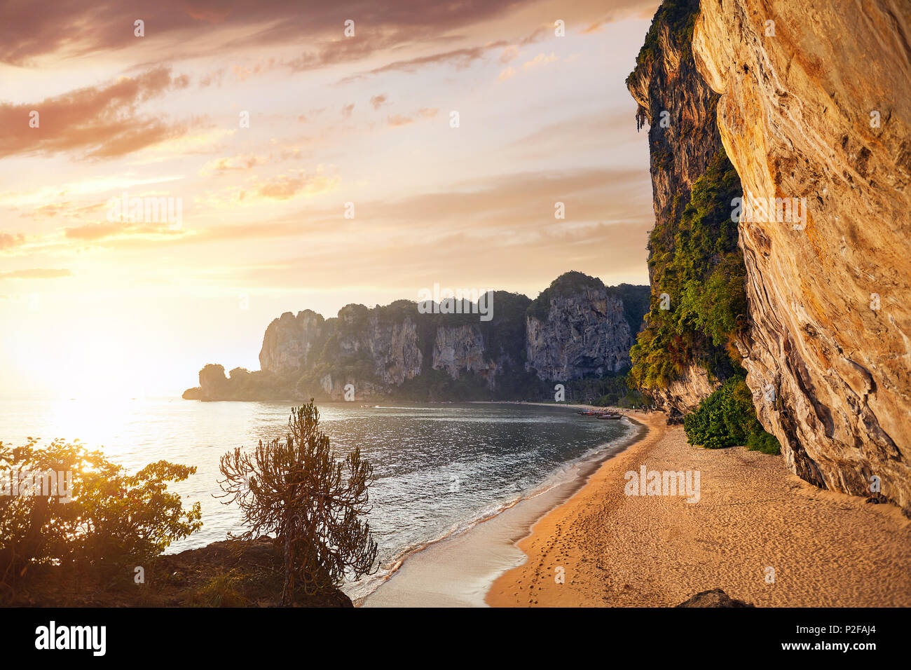 Bella Baia tropicale con spiaggia di sabbia e roccia al tramonto nel Mare delle Andamane, Thailandia Foto Stock