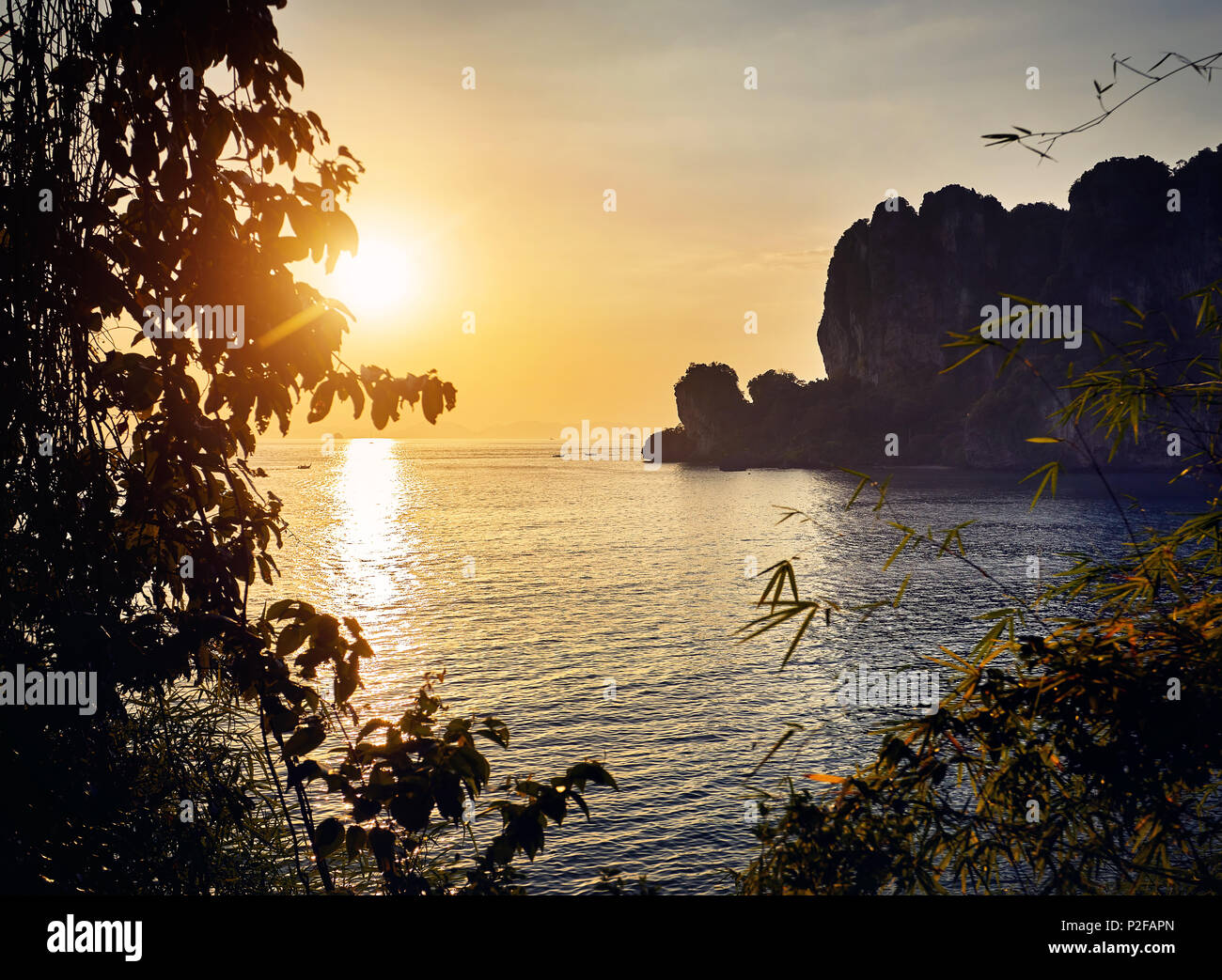 Bella Baia tropicale con spiaggia di sabbia e roccia al tramonto nel Mare delle Andamane, Thailandia Foto Stock
