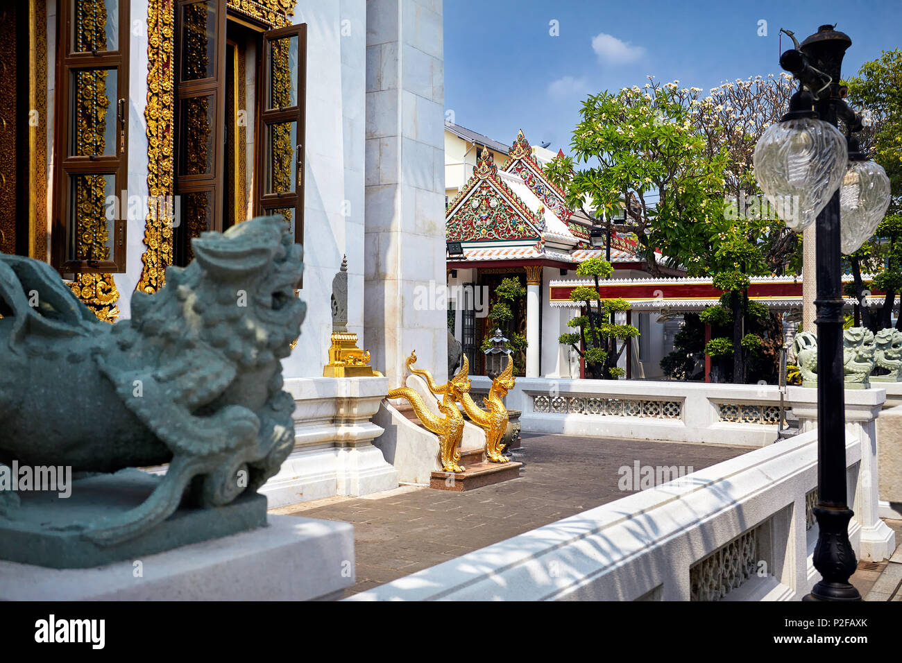 Dragoni dorati accanto all'ingresso del tempio buddista a Bangkok, in Thailandia Foto Stock