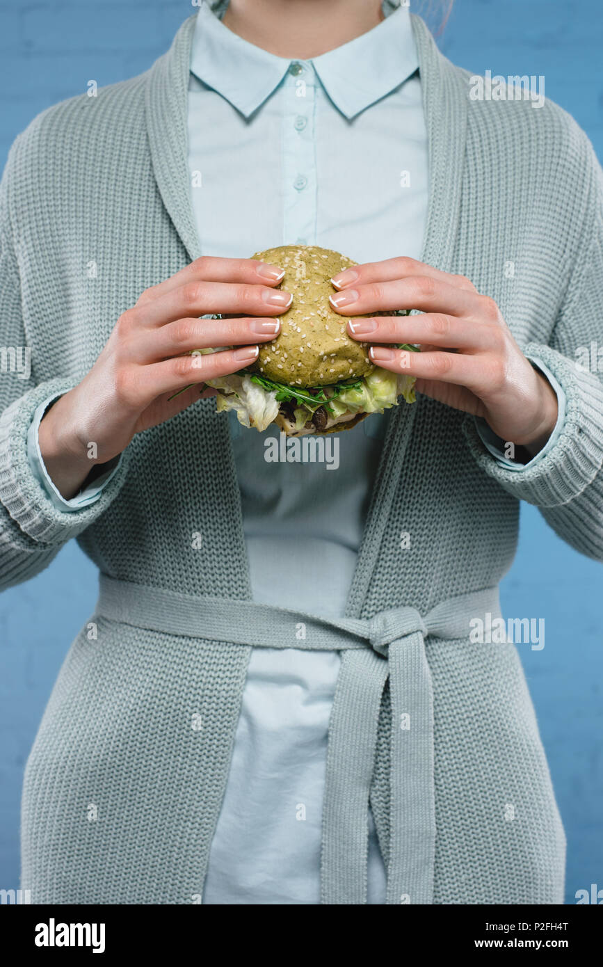 Ritagliato colpo di donna azienda green vegan burger Foto Stock