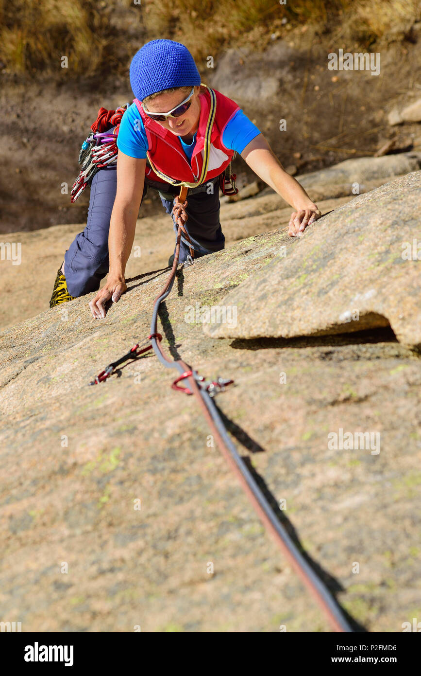 Donna arrampicata su granito rosso rock, il Mottarone, Piemonte, Italia Foto Stock