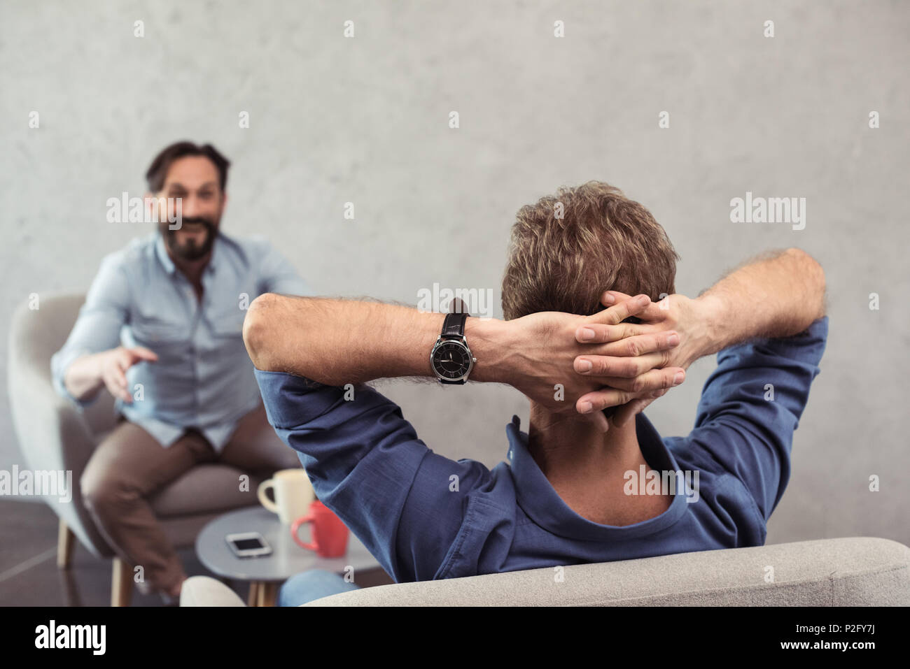 Casual imprenditori maturo di parlare mentre è seduto alla pausa caffè Foto Stock