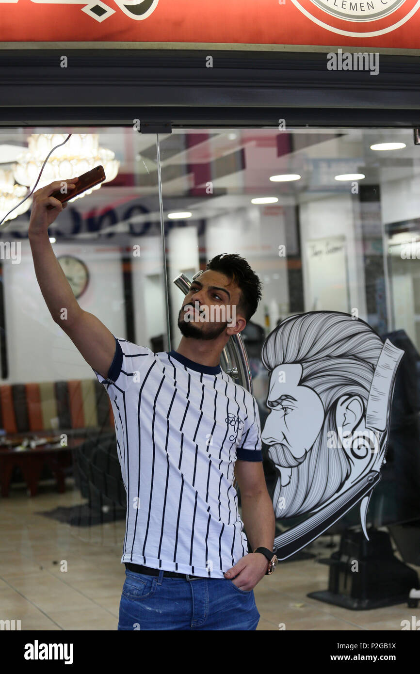 Rusholme, Manchester, Regno Unito. 15 GIU, 2018. Un uomo prendendo un selfie al di fuori di un barbiere durante le celebrazioni eid di Rusholme, 15 giugno 2018 (C)Barbara Cook/Alamy Live News Foto Stock