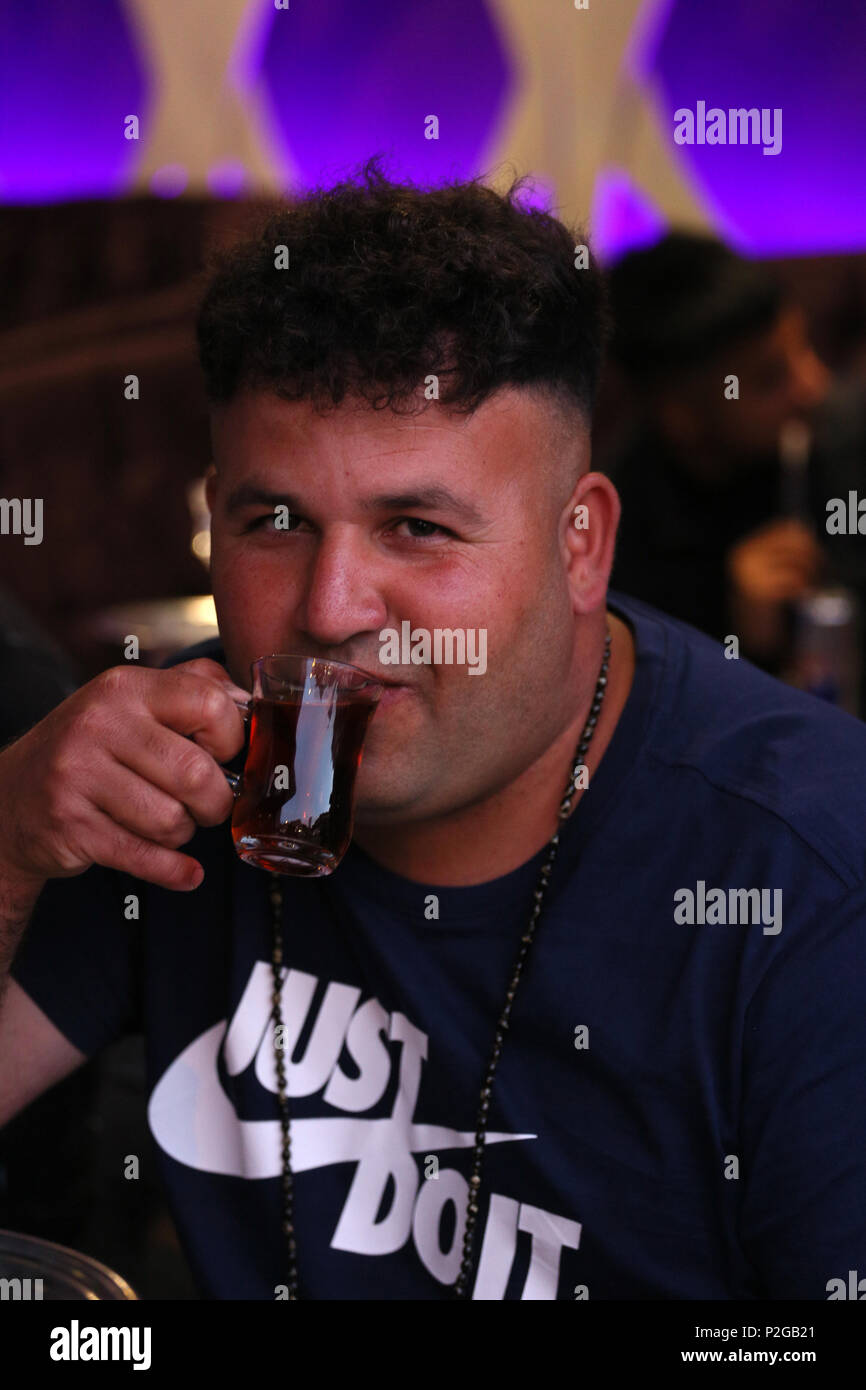 Rusholme, Manchester, Regno Unito. 15 GIU, 2018. Un uomo che indossa un 'Just do it shirt bere caffè arabo come Eid celebrazioni hanno luogo in Rusholme, 15 giugno 2018 (C)Barbara Cook/Alamy Live News Foto Stock