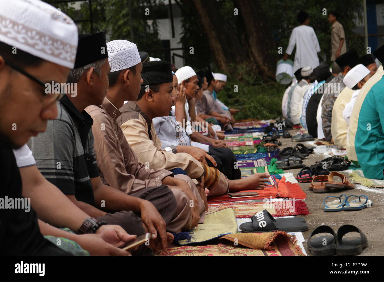 Makassar, Indonesia. 15 GIU, 2018. Un numero di musulmani sono seduti in modo folle in attesa per la attuazione di Eid preghiere in Makassar, Giugno 15, 2018 Credit: Herwin Bahar/Alamy Live News Foto Stock