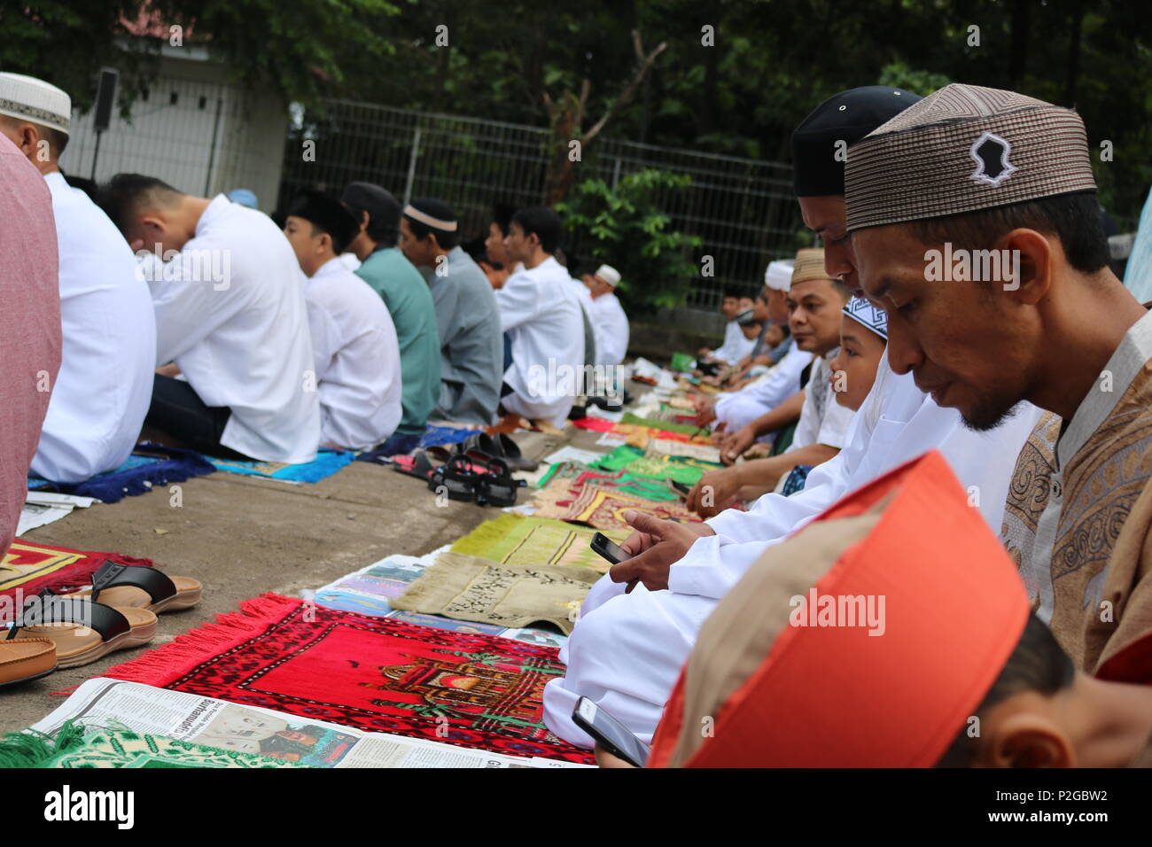 Makassar, Indonesia. 15 GIU, 2018. Un numero di musulmani sono seduti in modo folle in attesa per la attuazione di Eid preghiere in Makassar, Giugno 15, 2018 Credit: Herwin Bahar/Alamy Live News Foto Stock