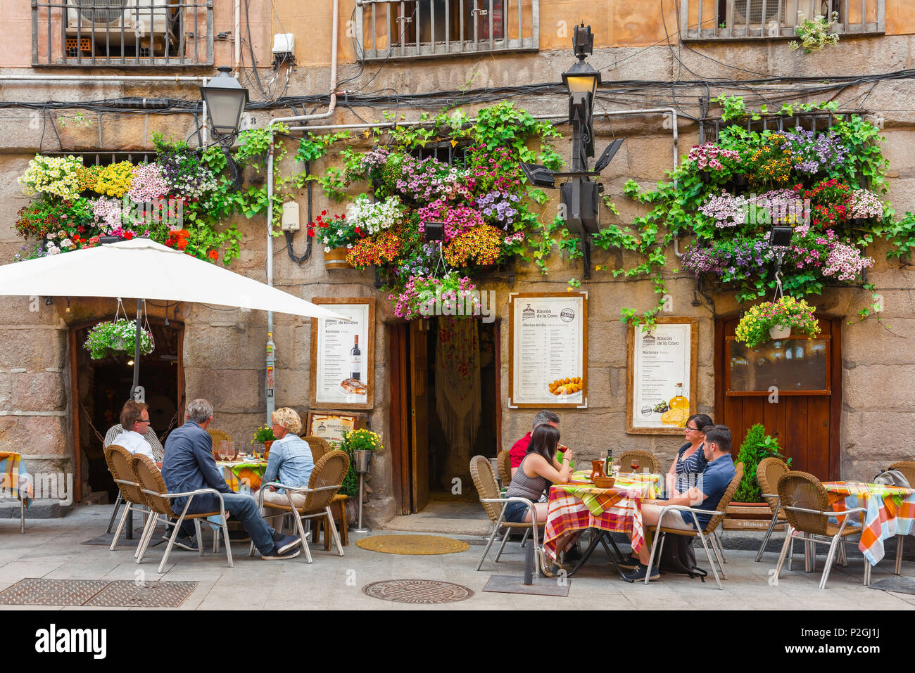 Caffè di strada di Madrid, vista su un pomeriggio estivo di persone che si rilassano ai tavoli da caffè nella storica Calle Cuchilleros centro storico quartiere di Madrid, Spagna. Foto Stock