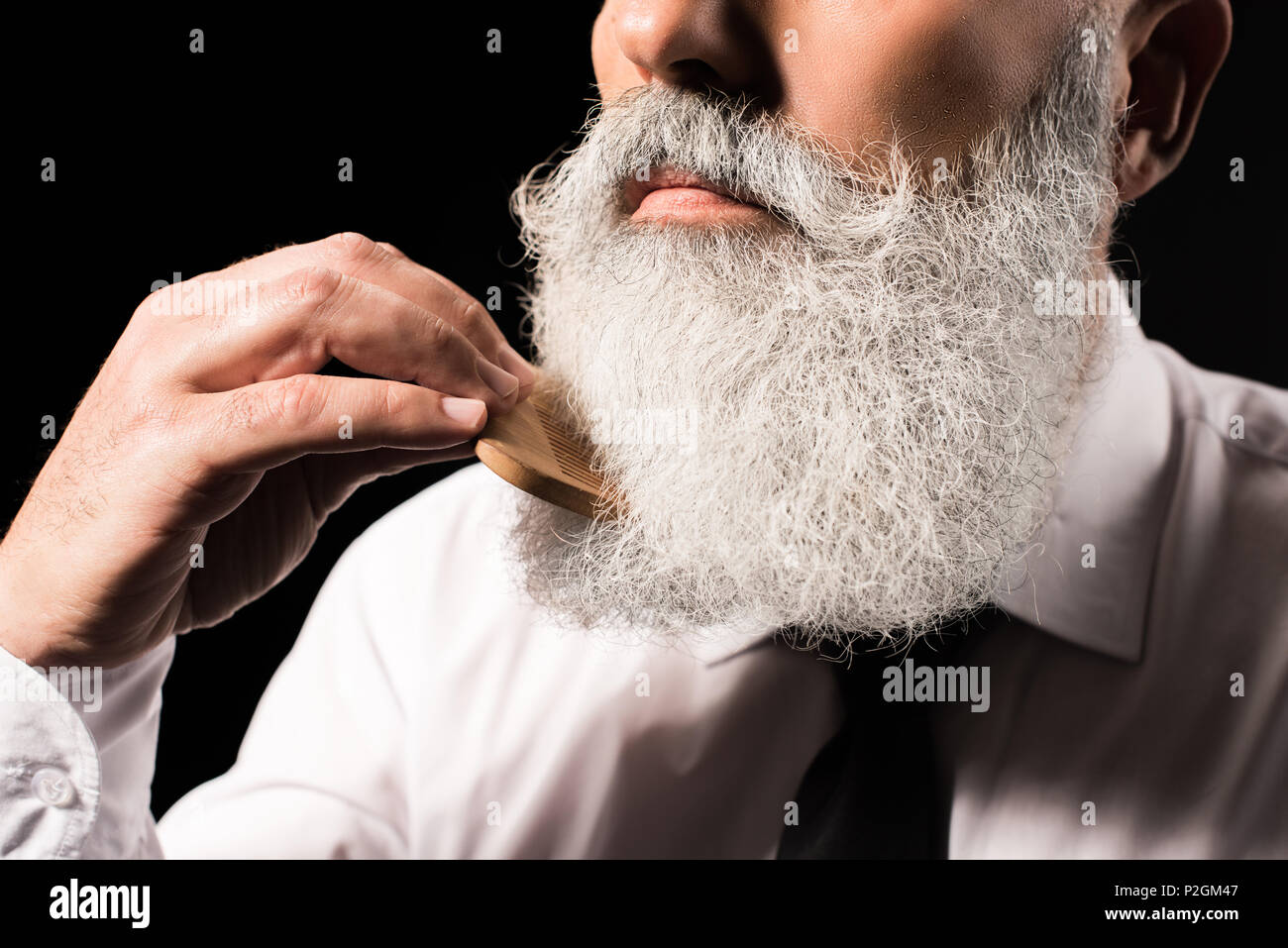 Tagliate il colpo di un uomo la pettinatura della sua lunga barba Foto Stock