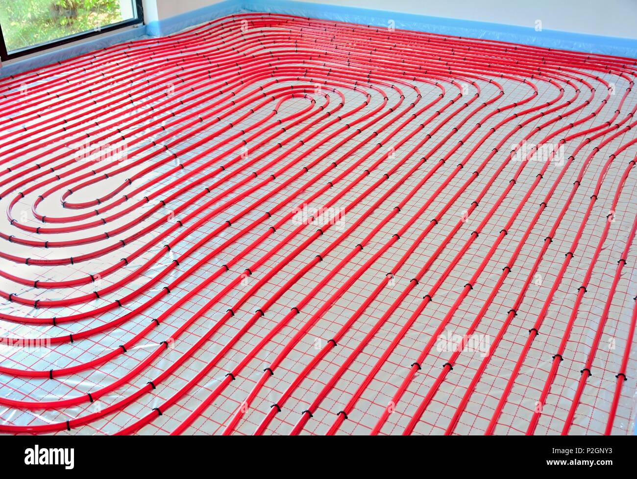 L'acqua di riscaldamento a pavimento tubazioni sull'argento lamina riflettente in costruzione casa. Foto Stock