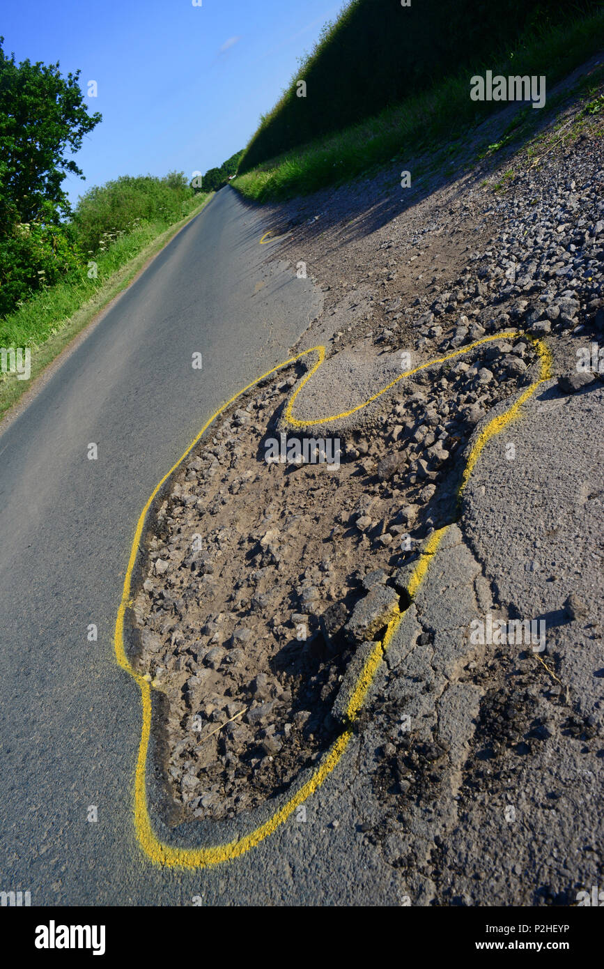 Enorme buca sul paese strada contrassegnata con contorno giallo per la riparazione,york yorkshire unitedc unito Foto Stock