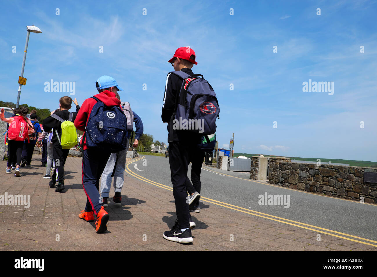 Vista posteriore dei bambini in gita scolastica su un cielo blu giornata di primavera gita in Pembrokeshire West Wales UK KATHY DEWITT Foto Stock