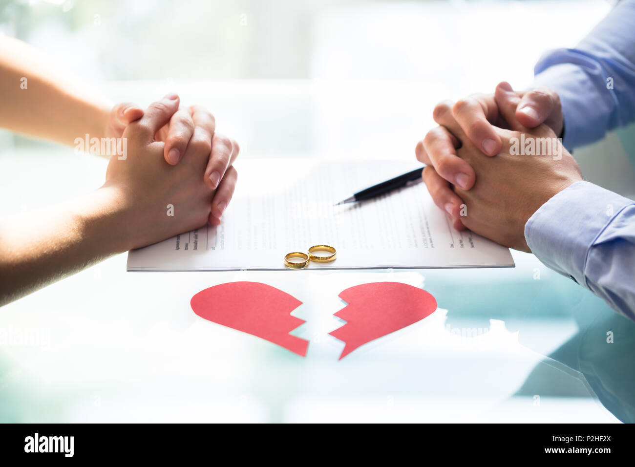Accoppiare la mano sul divorzio la carta con gli anelli di nozze e cuore spezzato Foto Stock