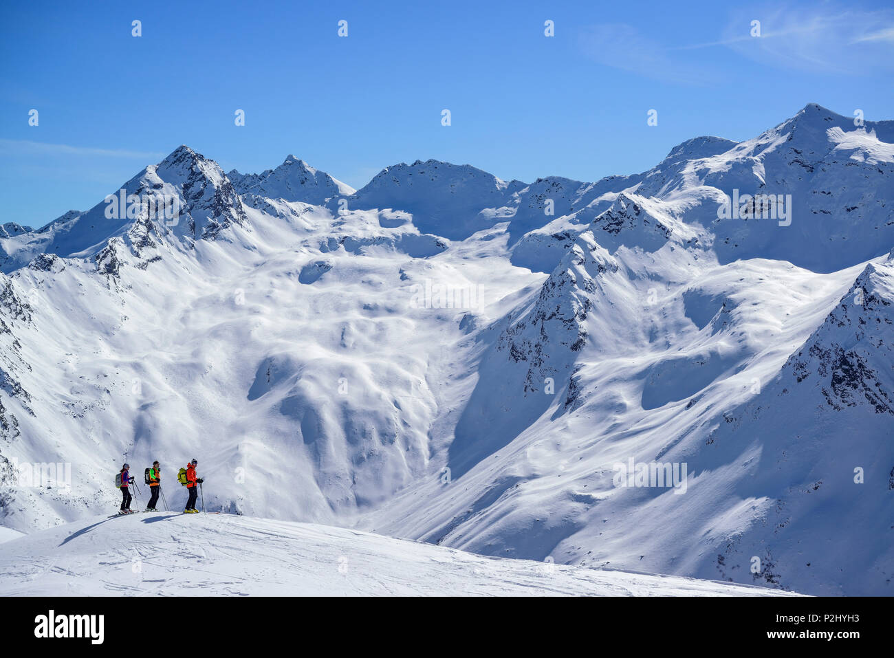 Tre persone indietro-paese sci guardando verso Alpi dello Stubai, Schneespitze, valle di Pflersch, Alpi dello Stubai, Alto Adige, Italia Foto Stock