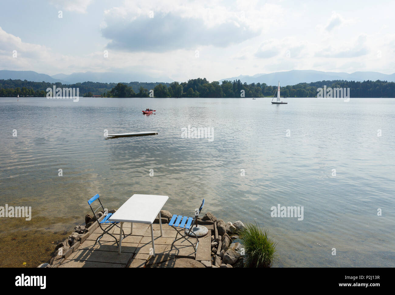 Tavolo e sedie sulle rive di Buchau isola, Staffelsee, vicino a Murnau, Terra Blu, distretto di Garmisch-Partenkirchen, bavarese al Foto Stock