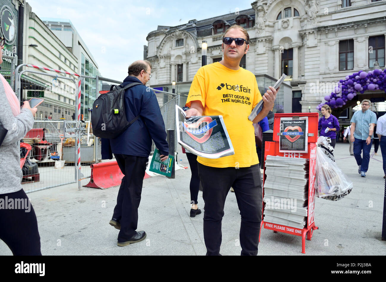 Uomo di consegnare la libera London Evening Standard presso la stazione Victoria di Londra, Inghilterra, Regno Unito. Sponsorizzato da Betfair Foto Stock