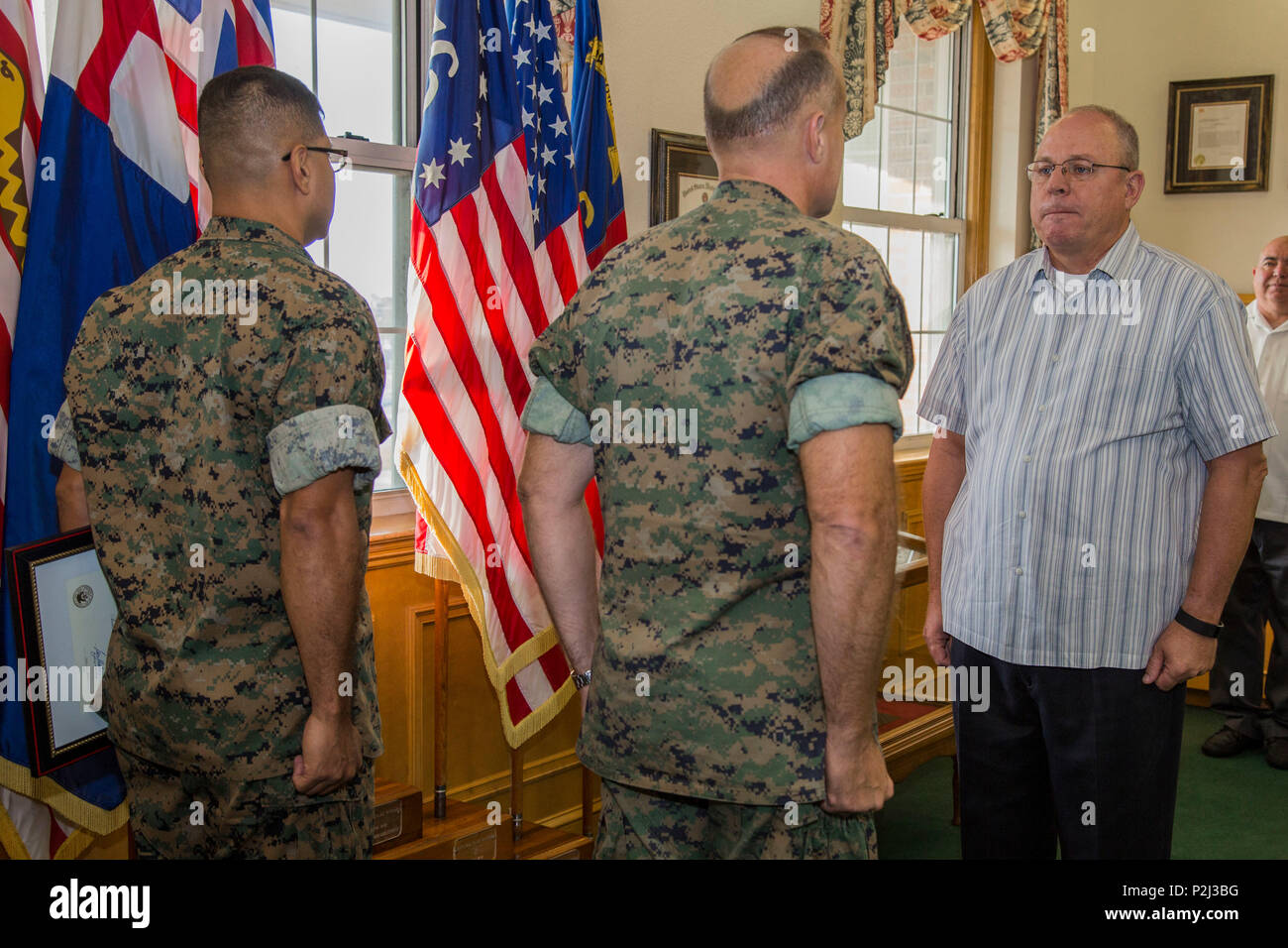 Ritirato U.S. Marine Corps Master Gunnery Sgt. Steven M. Rhoades, destra, Manpower management analyst, Marine Corps Impianti Oriente (MCIEAST), Col. Michael L. Scalise, centro, vice comandante, MCIEAST, e Master Sgt. Carlos G. Arbelaez, Pianificazione carriera, MCIEAST, stand in corrispondenza della posizione di attenzione durante Rhoades' cerimonia di premiazione, Camp Lejeune, N.C., Sett. 28, 2016. Il career service award è stato presentato a Rhoades dopo quaranta anni di onorato e fedele servizio per gli Stati Uniti La marina e il governo degli Stati Uniti. (U.S. Marine Corps photo by Lance Cpl. Judith L. Harter) Foto Stock