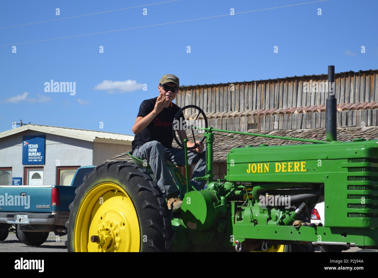 Un uomo che cavalca un trattore d'epoca in 58th annui Dell Valle Hudspeth County Fair di Main Street Parade in città Dell, Texas, Sett. 24, 2016. La Prima Divisione Corazzate banda anche hanno marciato in parata. Foto Stock