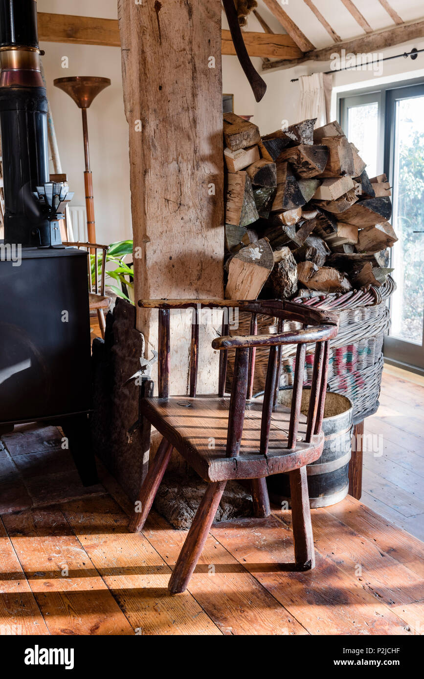 Sedia gallese e legna da ardere in Sussex fienile conversione Foto Stock