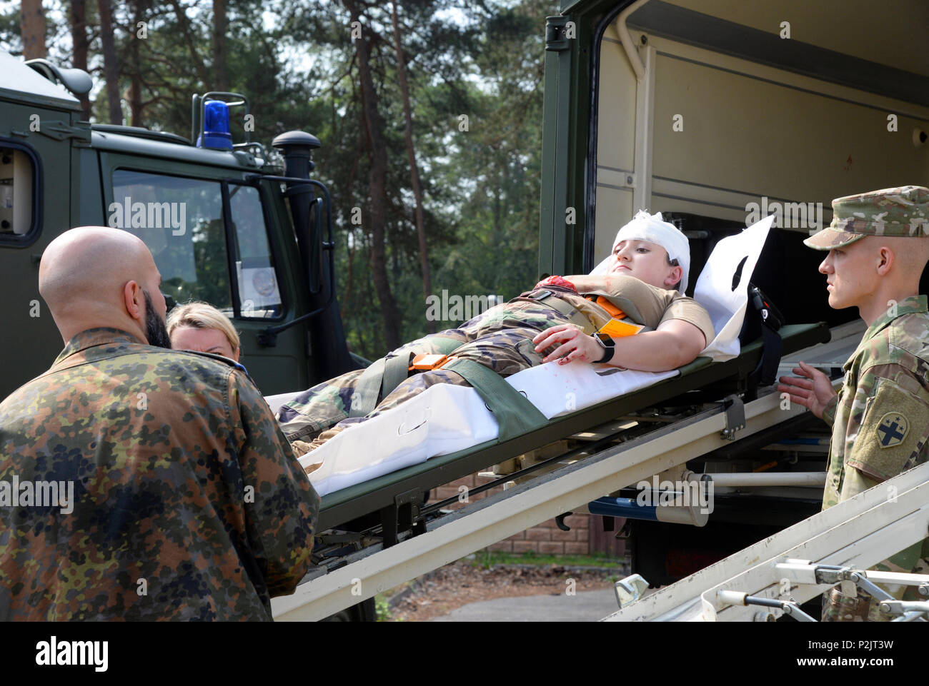 Stati Uniti Air Force, U.S. L'esercito tedesco e il personale medico il trasporto di un paziente con la classificazione tende durante una simulazione come parte di esercizio Maroon Surge su Ramstein Air Base, Germania Giugno 8, 2018. Partecipa inoltre condotto in grado di sopravvivere e di operare la formazione, o ATSO per migliorare le loro prestazioni durante le circostanze stressanti. (U.S. Air Force foto di Airman 1. Classe Ariel Leighty) Foto Stock
