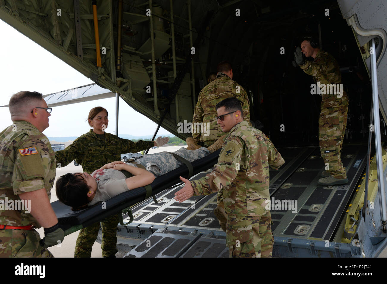 Stati Uniti Air Force, U.S. Esercito Croato e il personale medico a caricare un paziente su un C130J Super Hercules aeromobile durante la fase di esercizio Maroon Surge su Ramstein Air Base, Germania, 9 giugno 2018. Il personale medico a trasferire i pazienti dal specialmente attrezzati bus medica per gli aeromobili che devono essere trasportate per ulteriore trattamento. (U.S. Air Force foto di Airman 1. Classe Ariel Leighty) Foto Stock