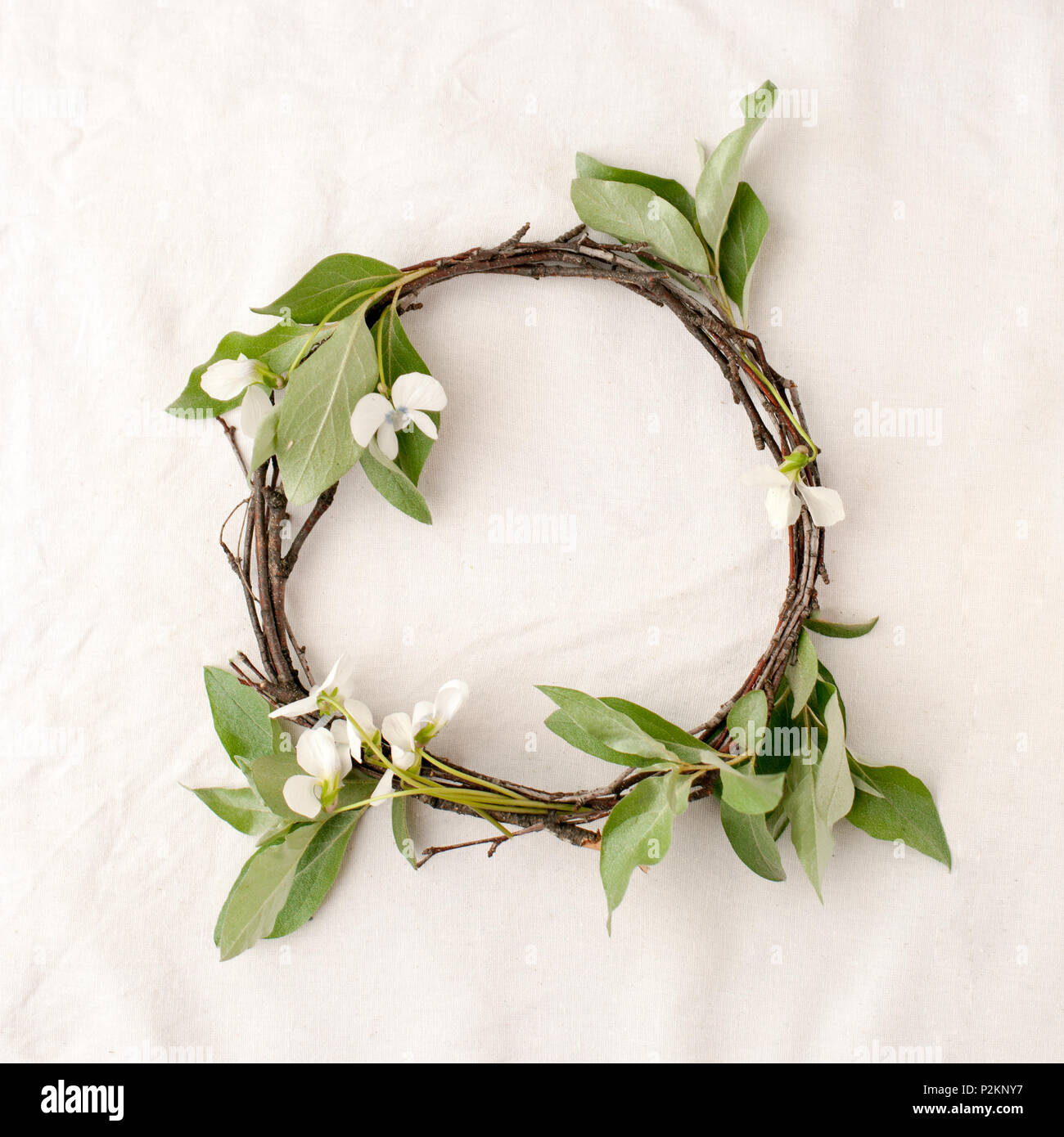 Composizione floreale. Ghirlanda fatta di roools, foglie e fiori di tessuto su sfondo bianco. Rustico stile home decor, piatto di laici che, vista dall'alto. Foto Stock