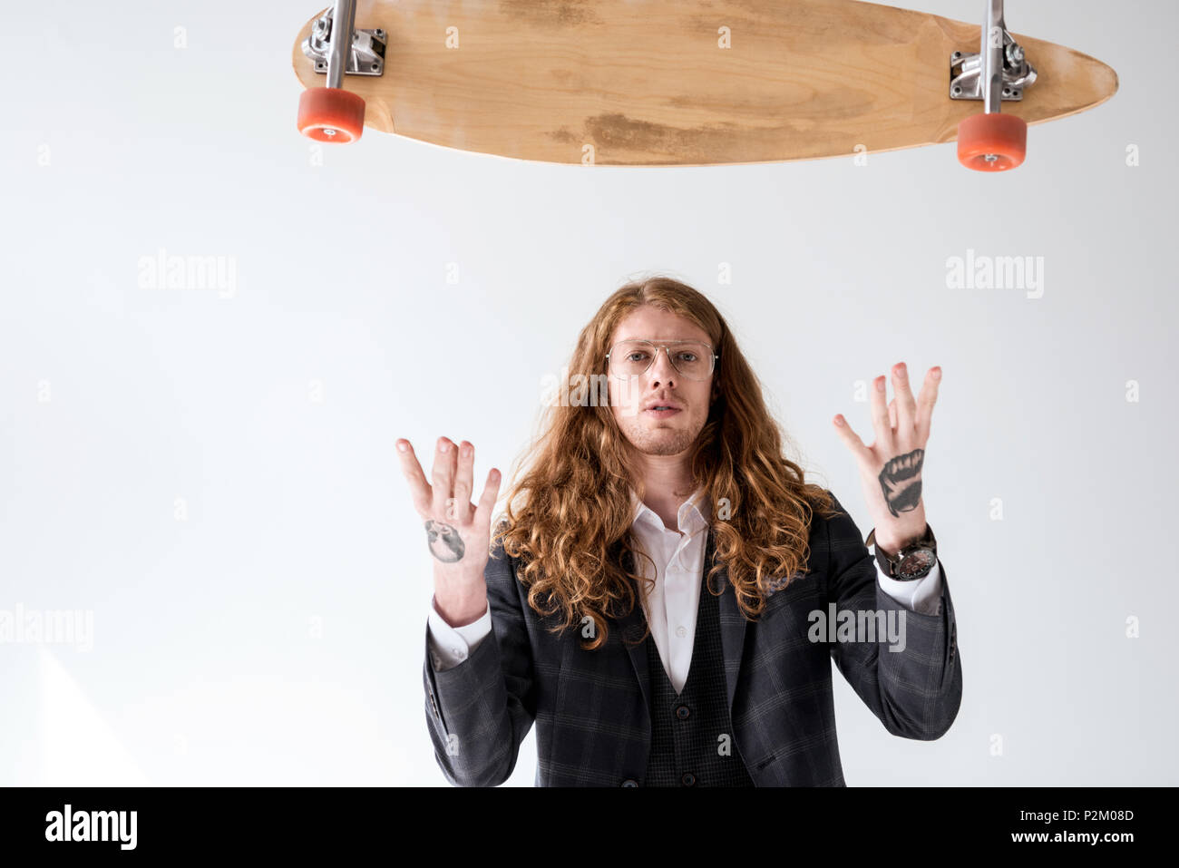 Elegante imprenditore con capelli ricci cattura la caduta di longboard isolato su bianco Foto Stock