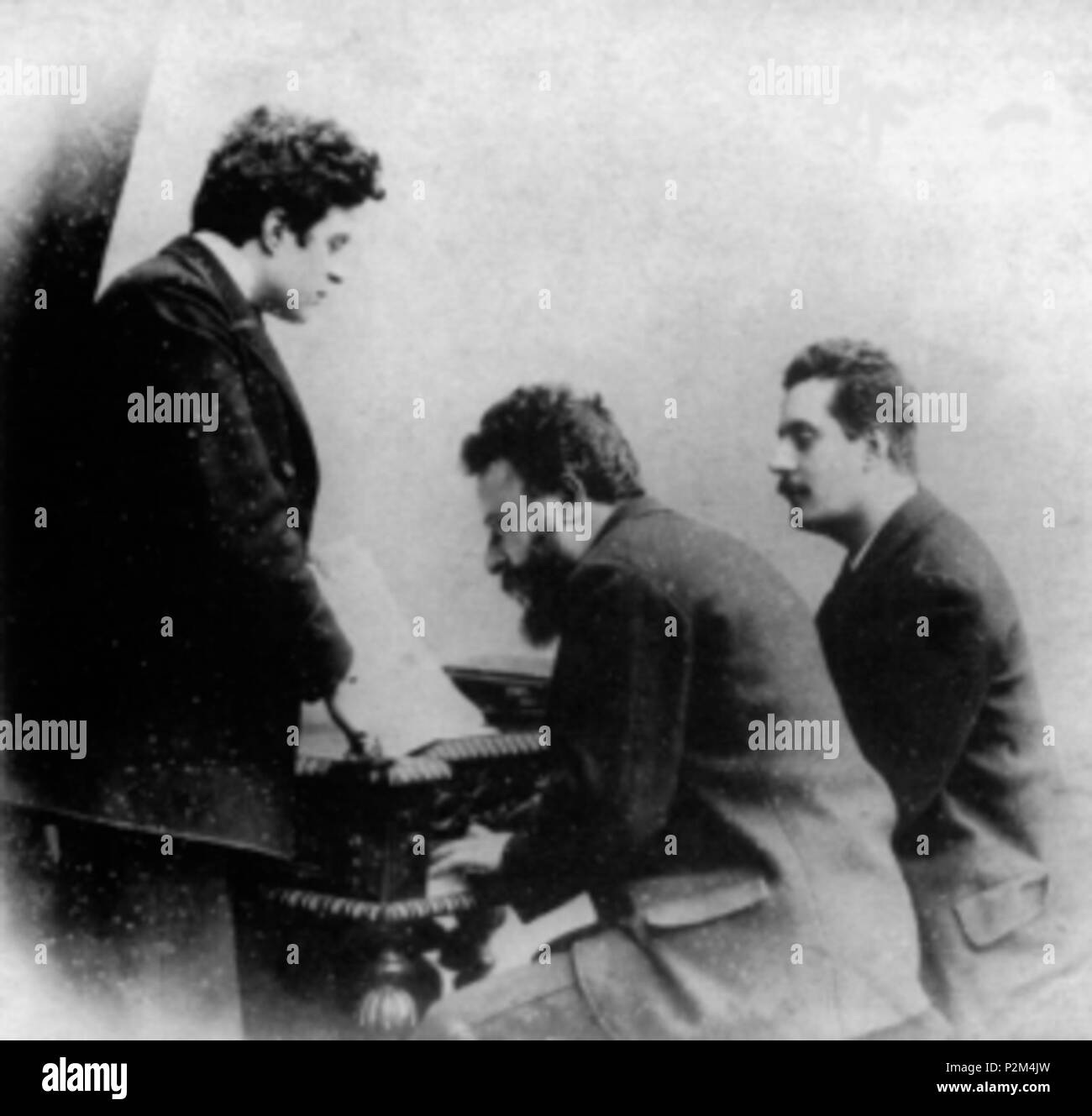. Italiano: Da sinistra, i musicisti Pietro Mascagni, Alberto Franchetti (al pianoforte) e Giacomo Puccini . circa 1885. Unknown 54 Mascagni-Franchetti-Puccini Foto Stock