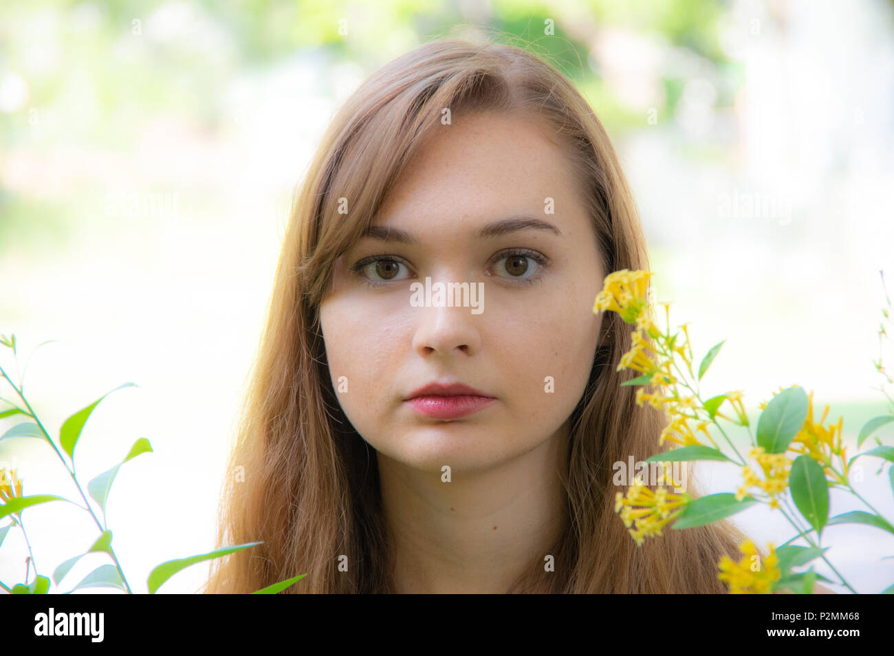 Piuttosto dai Capelli rossi ragazza con fiori di colore giallo Foto Stock