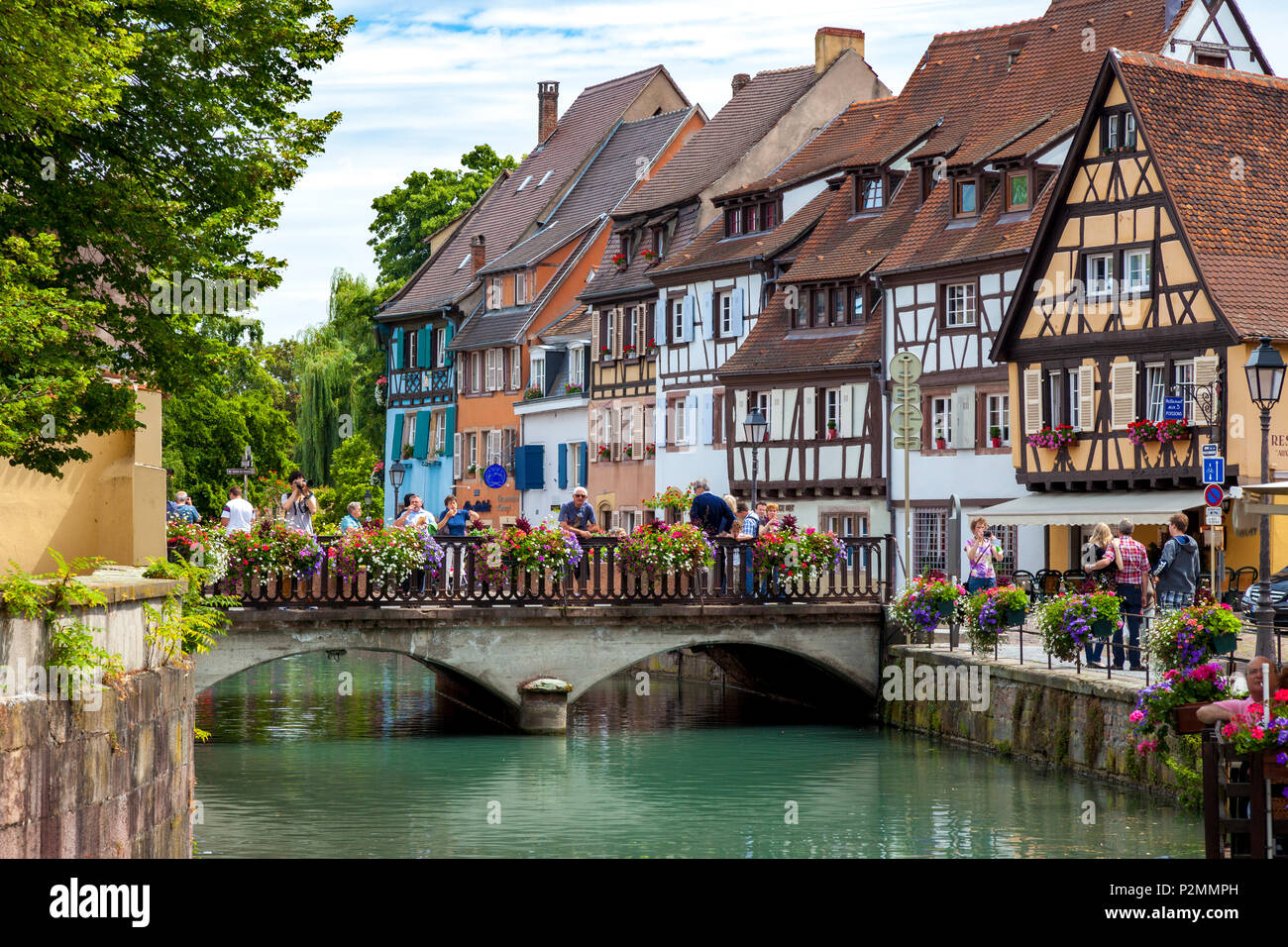 Turisti che si godono la Petite Venise - lungo il Quai de la Poisonnerie di Colmar, Alsace Francia Foto Stock