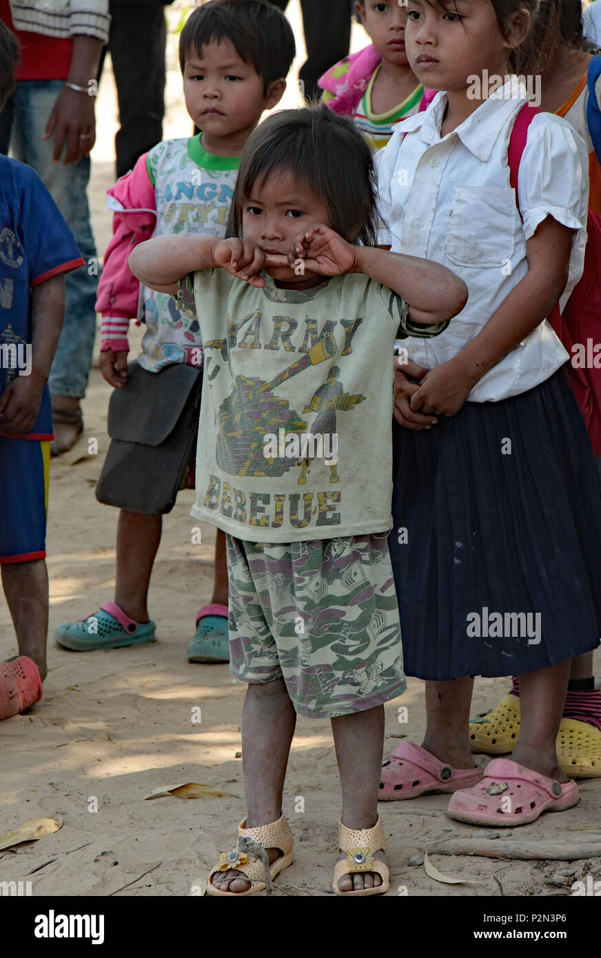 Un piccolo sporco bambino cambogiano attende in linea con gli altri bambini a risma scuola locale, Sihanouk provincia. Foto Stock