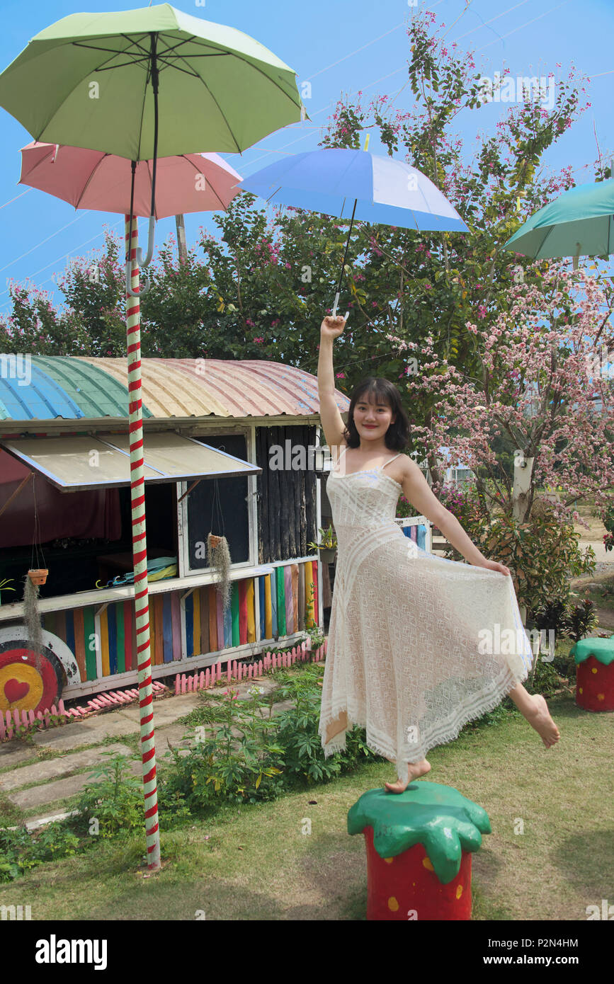 Ragazza con ombrello appeso dal filo Strawberry Farm Pai Mae Hong Son Provincia Nord della Thailandia Foto Stock