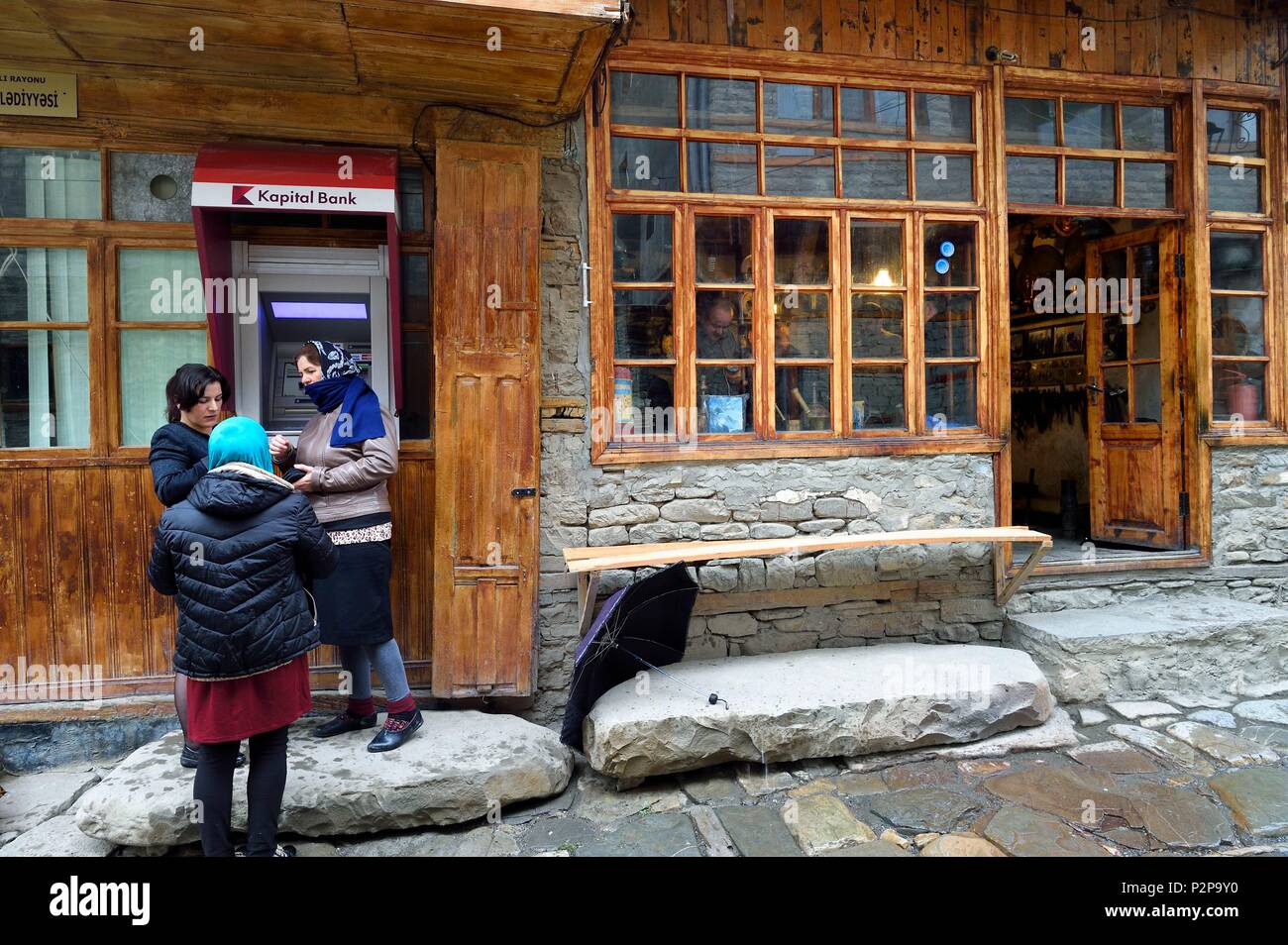 Azerbaigian, regione Ismailli, Lahij (Lahic) strada principale, le donne utilizzando un bancomat o ATM Foto Stock