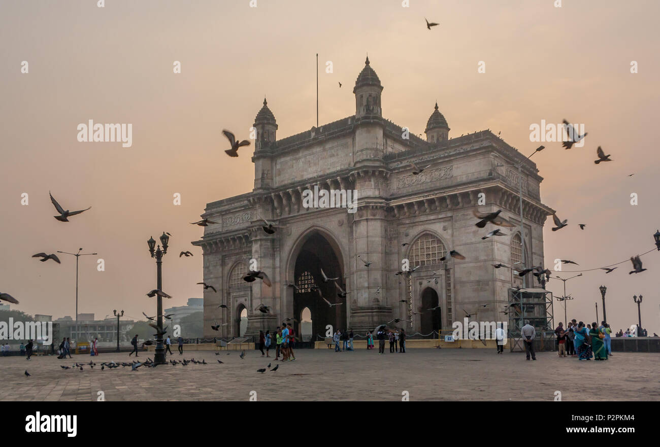 MUMBAI, India - 14 gennaio 2017 - persone non identificate a piedi e piccioni volare intorno al Gateway of India Foto Stock