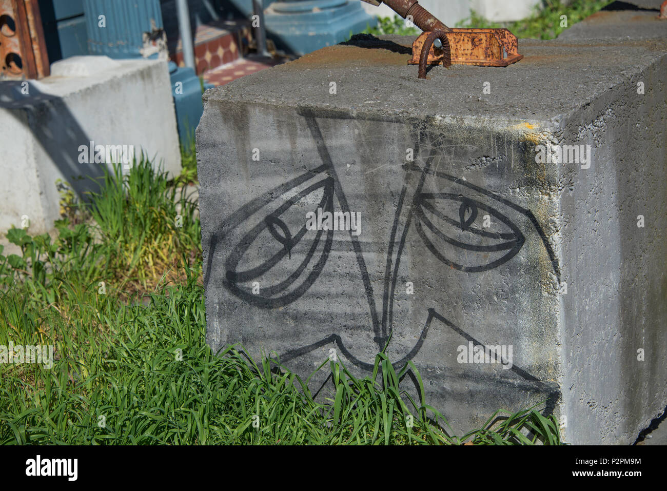Un blocco di cemento armato è stato dato un volto ad osservare i passanti. Foto Stock