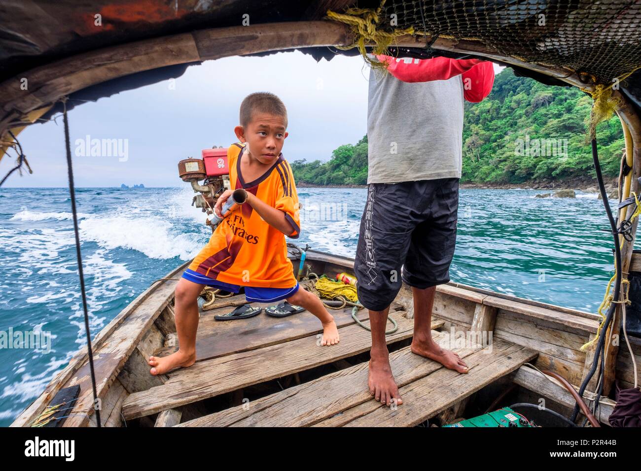 Thailandia, provincia di Satun, Mu Ko Phetra il Parco Marino Nazionale, Ko Bulon Leh island, di bambino e di suo padre alla guida di una tradizionale barca dalla coda lunga Foto Stock