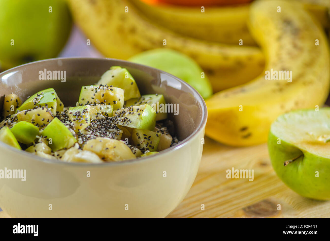 Sana Colazione ciotola: fiocchi d'avena con banana, mela verde, sesamo e semi di Chia Foto Stock