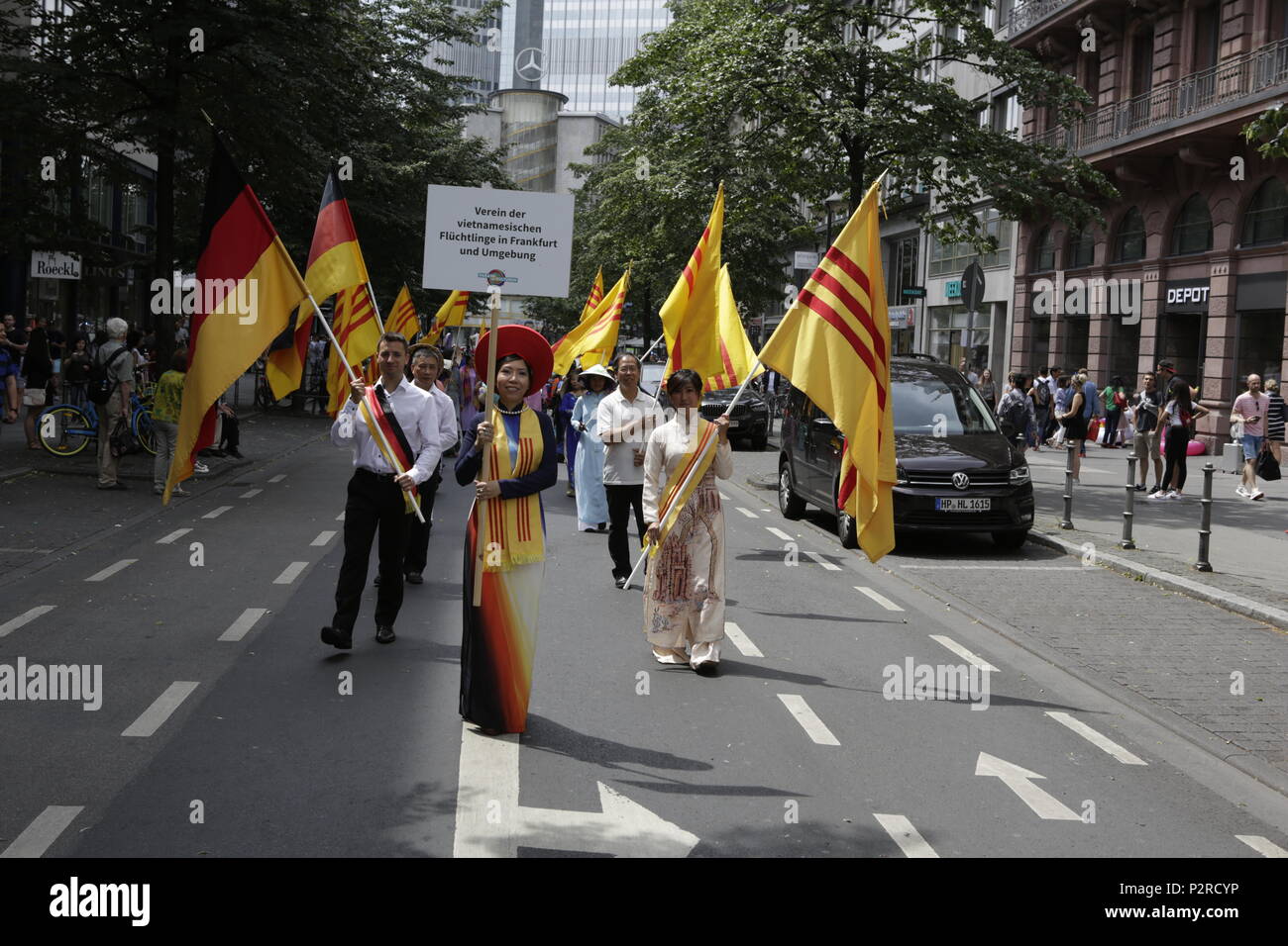 Francoforte, Germania. Il 16 giugno 2018. Rifugiati vietnamiti che indossa gli abiti tradizionali e la tessitura le bandiere della Repubblica socialista del Vietnam marzo in parata. Migliaia di persone hanno partecipato e guardato il 2018 Parade der Kulturen (sfilata di culture), organizzata dalla Frankfurter Jugendring (Francoforte la gioventù del Consiglio). La sfilata con partecipanti provenienti da oltre 40 diversi gruppi di expat e organizzazioni culturali che ha presentato la diversità culturale di Francoforte. Credito: Michael Debets/Alamy Live News Foto Stock